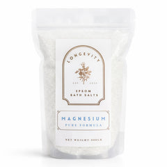 A white jar of AW GIFTS Longevity Magnesium Epsom Bath Salt with a label, placed next to a wooden scoop and relaxing spa setting.