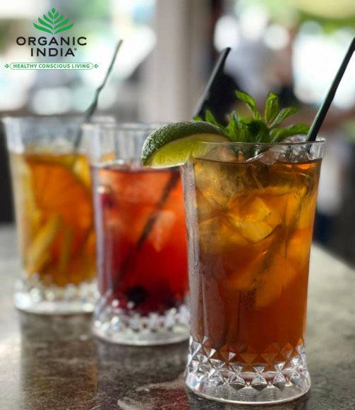 Organic India BIO Tulsi Wellness Tea in caffeine-free infusion bags, featuring fresh herbal tea leaves and vibrant packaging.