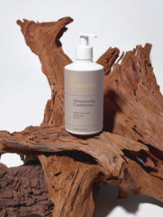 Selfnamed moisturizing conditioner bottle with a sleek design, showcasing smooth, shiny hair after use.